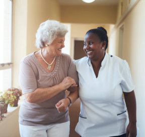 senior woman and caregiver smiling