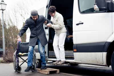 caregiver assisting senior man getting of the van