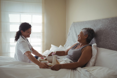 caregiver giving senior woman meal