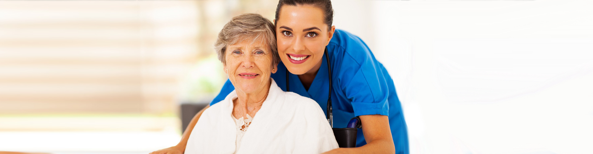 senior woman and caregiver smiling